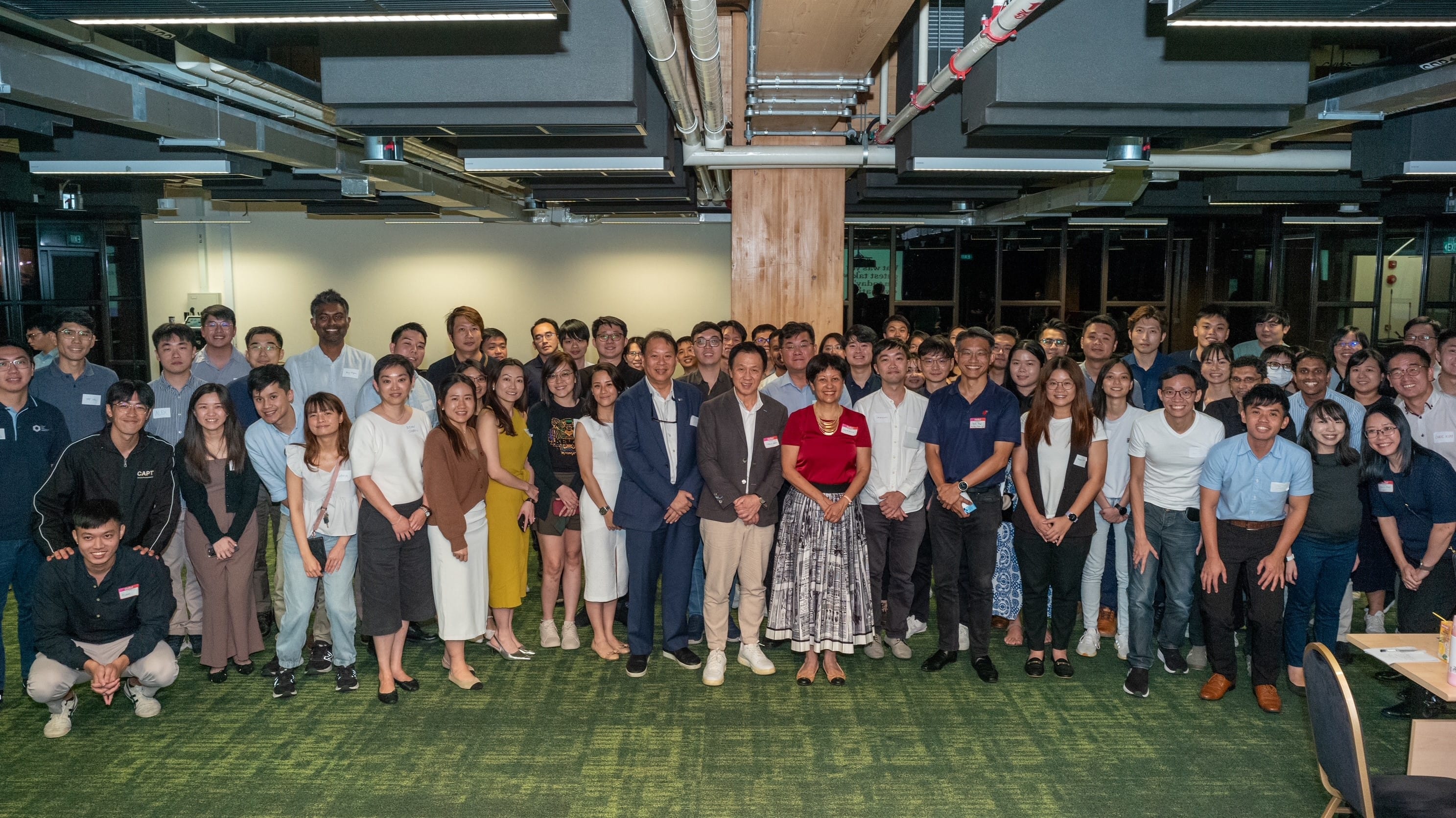 Large group photo of staff and leaders standing together indoors during a taskforce meeting or engagement session.